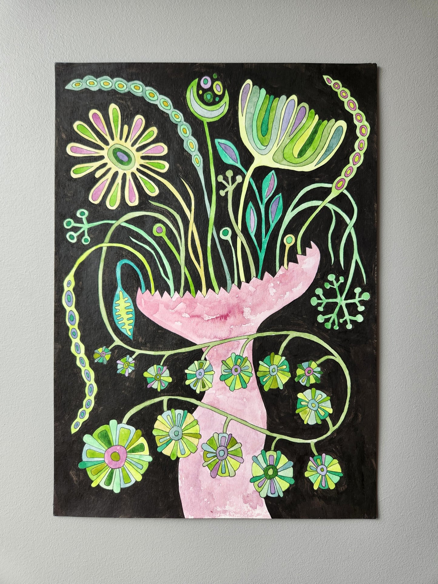 Original hand-painted floral artwork with Slavic folk art motifs, featuring a pink vase with vibrant green and pastel blossoms on a black background — photographed against a light grey wall.