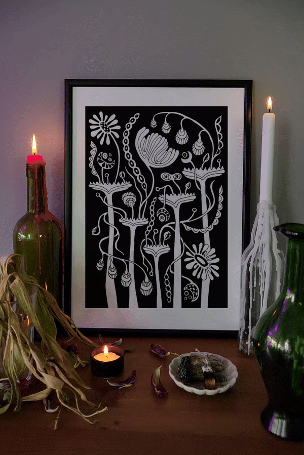Black and white botanical wall art print in mystical altar setting — framed floral poster with candles and crystals for spiritual home decor or witchy interiors.