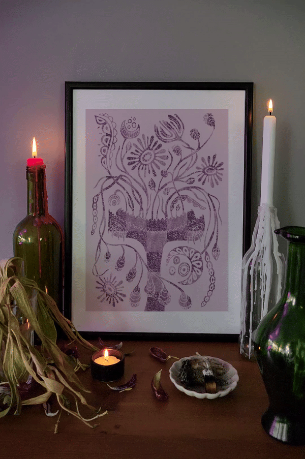 Lilac botanical wall art in a black frame, styled with candlelight and ritual objects—witchy home decor with mystical vibes.