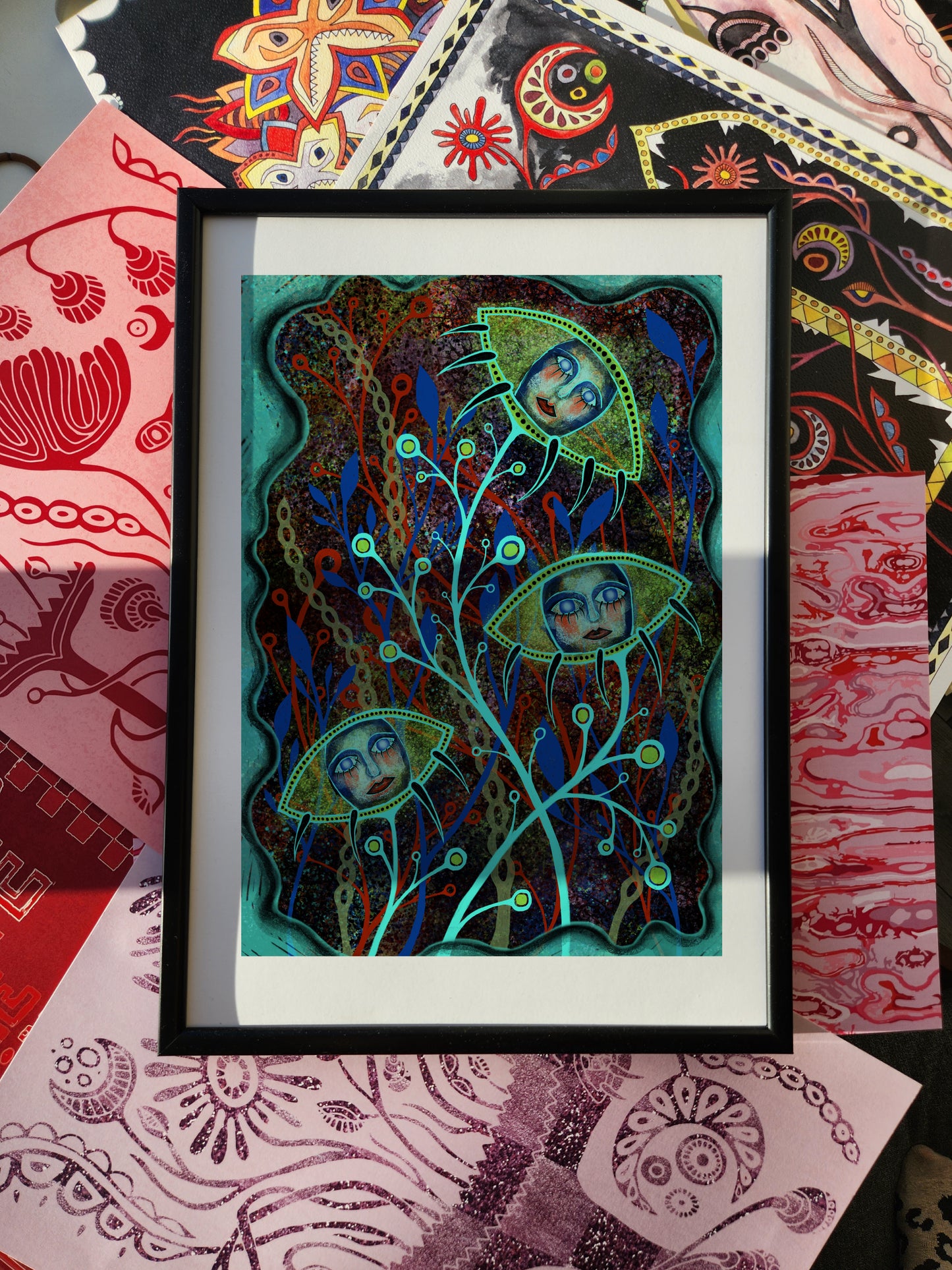 Fantasy poster and surreal wall art print depicting ethereal faces enclosed in floral pod-like forms with intricate branches, glowing colors, and mystical atmosphere, framed against an eclectic patterned background.