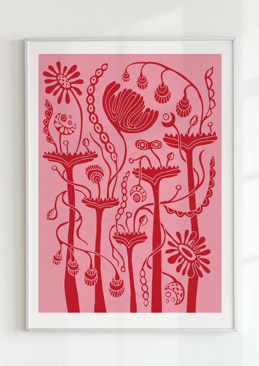 Framed art print of a surreal botanical illustration in red tones on a soft pink background, featuring whimsical abstract plants and folklore-inspired floral shapes, displayed in a modern white frame with natural light shadows.