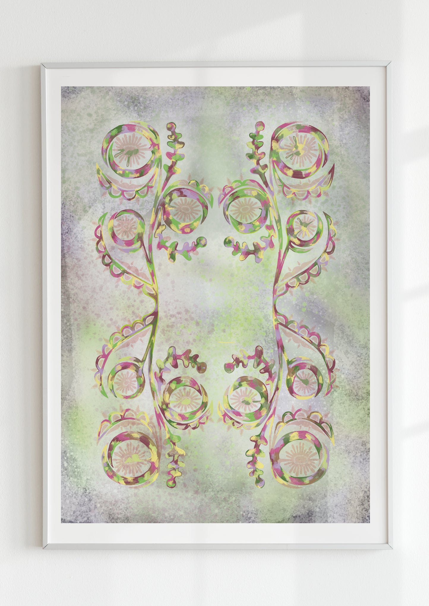 Abstract folk-inspired symmetrical floral art print in soft green and purple tones, framed in white and displayed on a textured light background.