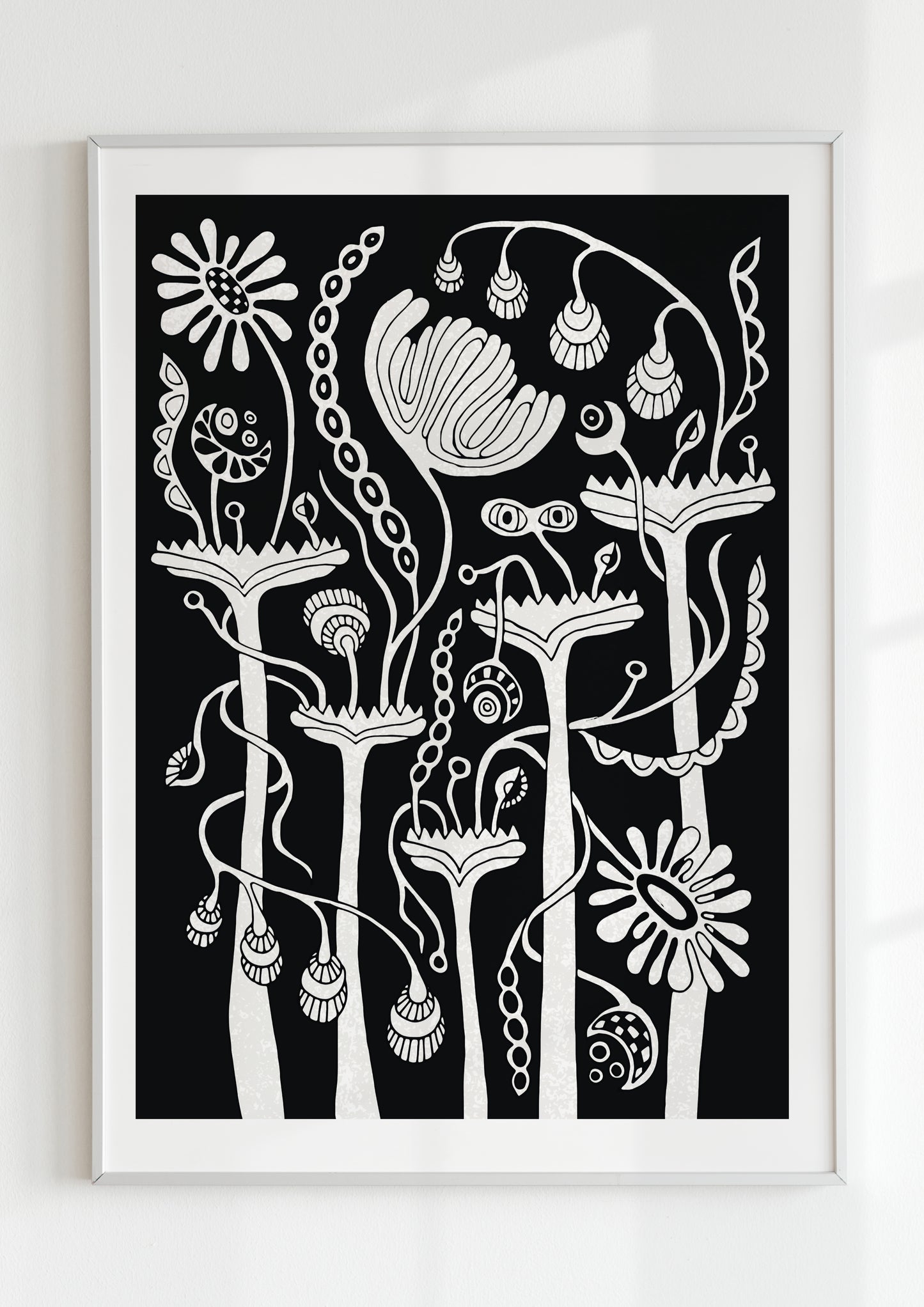 Modern black and white botanical wall art in a white frame — minimalist floral poster with folk art influence for eclectic or monochrome interiors.