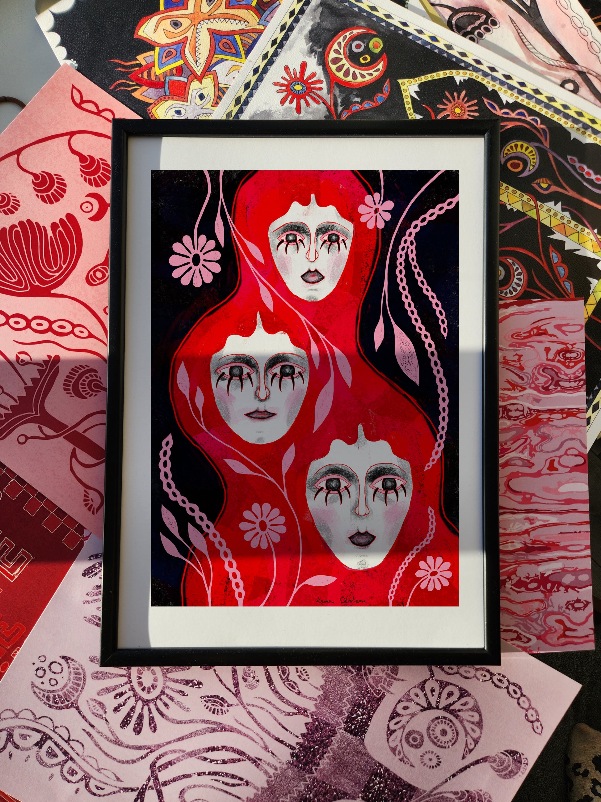 Abstract portrait poster featuring three surreal female faces with flowing red forms and floral motifs on a dark background, modern wall art print.