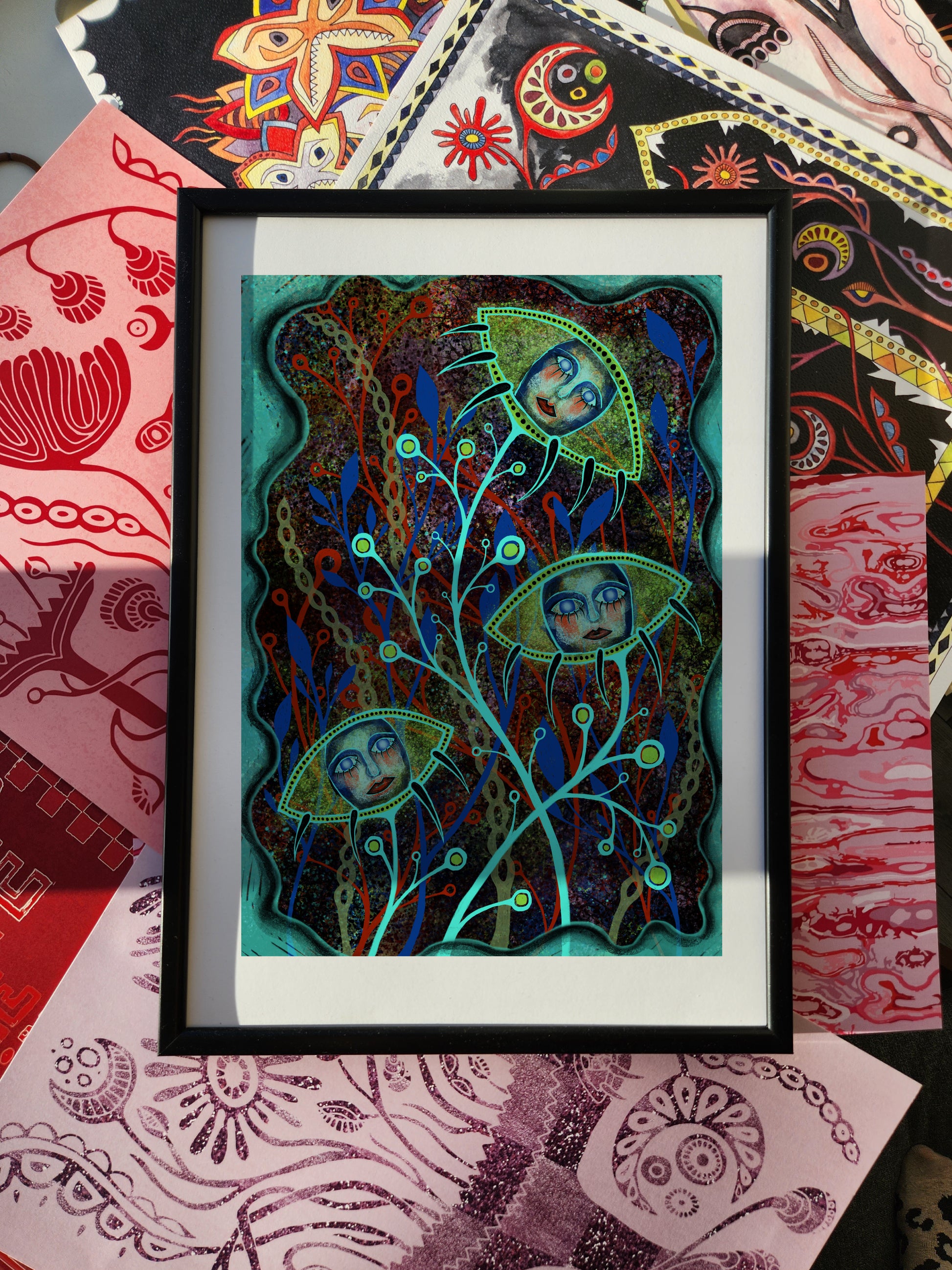 Fantasy poster and surreal wall art print depicting ethereal faces enclosed in floral pod-like forms with intricate branches, glowing colors, and mystical atmosphere, framed against an eclectic patterned background.